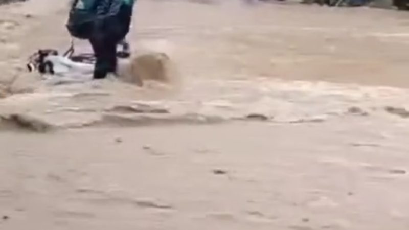 पहाड़ो में तेज़ बारिश ने बढ़ाई मुश्किलें, उफनती नदी की चपेट में आया बाइक सवार।